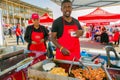 Diverse African vendors cooking and serving various bread based street food at outdoor festival