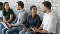 Diverse applicants holding devices talking while waiting turn job interview