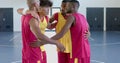 Diverse basketball players strategize on the court