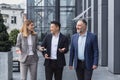 Diverse business group, three male and female workers walking and chatting discussing plans Royalty Free Stock Photo