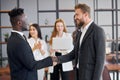 Diverse business male shaking hands in office Royalty Free Stock Photo