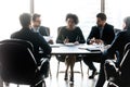 Diverse business partners discussing project, sitting at table in boardroom Royalty Free Stock Photo