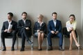 Diverse businesspeople applicants sitting in row waiting for job interview