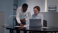 Diverse business people using laptop computer working together at desk in modern office. Royalty Free Stock Photo