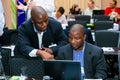 Diverse business persons going over data on digital devices at a meeting