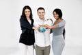 Diverse business team, students, coworkers, Caucasian and African women, Caucasian man, holding a terrestrial globe
