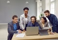 Diverse team of happy people use a laptop and tablet while working on a business project together Royalty Free Stock Photo