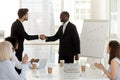 Diverse businessmen standing in office and shaking hands Royalty Free Stock Photo
