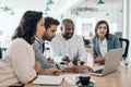 Diverse businesspeople smiling while working together on a laptop Royalty Free Stock Photo