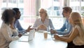 Multicultural professional team colleagues having conversation sit at conference table Royalty Free Stock Photo