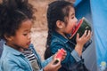 Diverse children of asian and african american friends enjoy eating watermelon together during going for camping countryside Royalty Free Stock Photo