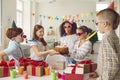 Diverse children in party hats and funny sunglasses are having fun at a children& x27;s birthday party. Royalty Free Stock Photo