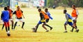 Diverse children playing soccer football at school