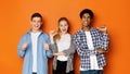 Diverse classmates pointing fingers at themselves, posing to camera Royalty Free Stock Photo