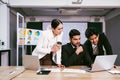 Diverse colleagues Asian and Caucasian working group meeting on project together, using laptop, sitting in office, discussing Royalty Free Stock Photo