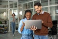 Diverse colleagues collaborating on project together using laptop Royalty Free Stock Photo