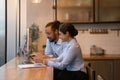 Diverse colleagues discuss job by laptop at office dining area