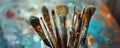 A diverse collection of different paintbrushes displayed in a jar on an artist's table. The Royalty Free Stock Photo