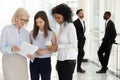 Diverse company employees having casual talks in company hallway Royalty Free Stock Photo