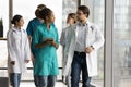 Diverse couple of young doctors walking in clinic office hall Royalty Free Stock Photo