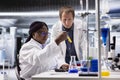 Diverse coworkers in biolab analyzing flasks and vials for chemical experiment Royalty Free Stock Photo
