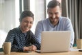 Diverse coworkers sitting at desk joking in the workplace Royalty Free Stock Photo