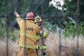 A diverse crew of firefighters from the LAFD puts out a brush fire on a vacant lot.