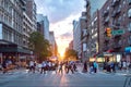 Diverse crowd of people walking across the busy intersection in New York City