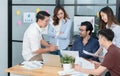 Diverse employees in office brainstorming while discussing ideas for new project, using laptop. Multiracial coworkers gather in Royalty Free Stock Photo