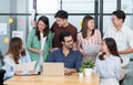Diverse employees in office having fun during brainstorming while discussing ideas for new project, using laptop. Multiracial Royalty Free Stock Photo