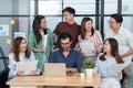 Diverse employees in office having fun during brainstorming while discussing ideas for new project, using laptop. Multiracial Royalty Free Stock Photo
