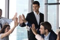 Diverse employees team giving high five at meeting, celebrating success Royalty Free Stock Photo