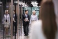 Diverse employees walk down office hallway talking Royalty Free Stock Photo