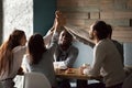 Diverse excited best friends giving high-five together at cafe m Royalty Free Stock Photo