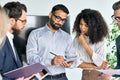 Diverse executive team managers reading contract standing in boardroom.