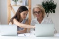 Diverse female colleagues work on laptops brainstorming