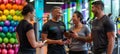 Diverse fitness group using phones in lively gym with colorful exercise equipment