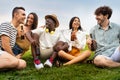 Diverse friends enjoying time outdoors. Multiracial young people having fun together drinking beer and laughing outdoors Royalty Free Stock Photo