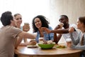 Cheerful diverse friends sitting together at table drinking coff