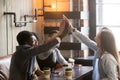 Diverse friends join hands together giving high-five at cafe mee Royalty Free Stock Photo