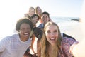 Diverse friends smile for a selfie on a sunny beach