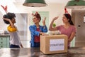 Diverse friends sorting donations box at kitchen island in headbands under lights Royalty Free Stock Photo