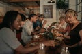 Diverse friends talking over a bistro dinner at night Royalty Free Stock Photo