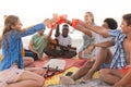 Diverse friends toast on a beach at sunset, having a party, with copy space Royalty Free Stock Photo