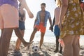 Diverse friends, who are young adults, enjoy a casual game of soccer on the beach Royalty Free Stock Photo