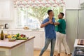 Diverse gay male couple spending time in kitchen dancing Royalty Free Stock Photo