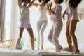 Diverse girls best friends wearing pajamas jumping on bed Royalty Free Stock Photo