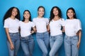 Diverse Girls Embracing Posing On Blue Background, Smiling To Camera