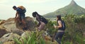 A diverse group of active mountain hikers walking on a lush green trekking trail. Friend clique bonding on a social hike