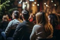 Diverse group backs of young people sitting outdoors man woman students listening speaker watching presentation Royalty Free Stock Photo